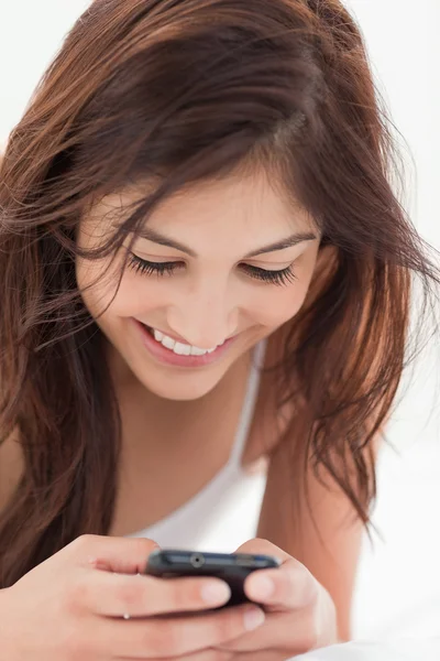 Bliska, kobieta za pomocą jej smartphone i uśmiechając się — Zdjęcie stockowe