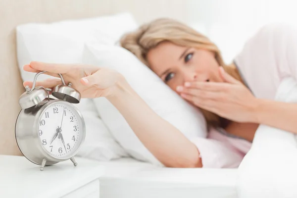 Mulher acordando, bocejando e chegando ao silêncio despertador — Fotografia de Stock