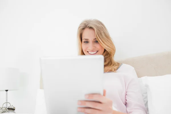 Colpo basso angolo, donna che utilizza tablet pc e sorridente — Foto Stock