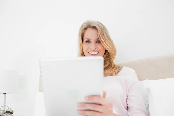 Niski kąt strzału, kobieta przy użyciu komputera typu tablet w uśmiechając się i looki — Zdjęcie stockowe