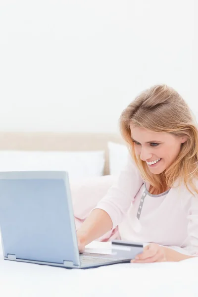 De cerca, Mujer usando el ordenador portátil en la cama mientras mira el scr —  Fotos de Stock
