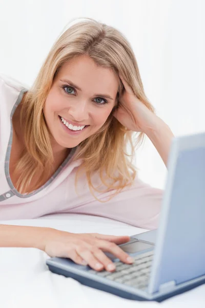 Close-up, vrouw met haar hand op haar laptop, glimlachend en op zoek — Stockfoto