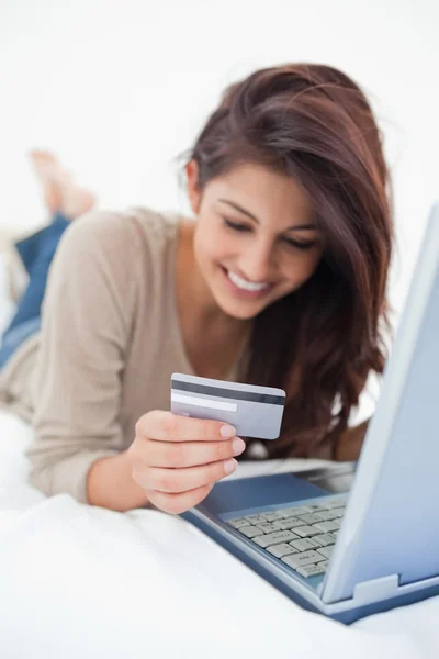 Focus shot, woman looking at her credit card in front of her lap — Stock Photo, Image