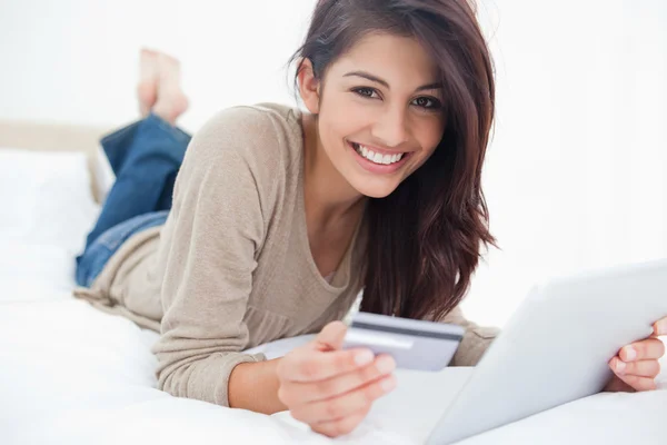 Vrouw kijken rechtdoor, met haar creditcard en tablet in — Stockfoto