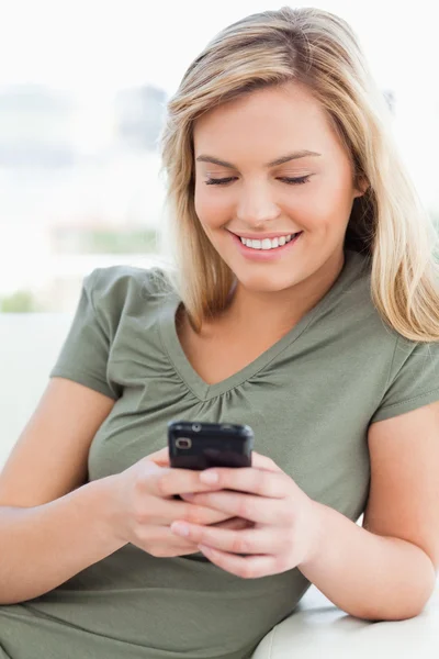 De cerca, la mujer sonriendo y usando su teléfono — Foto de Stock