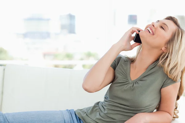 Mujer con la cabeza levantada hacia atrás y sonriendo mientras hace una llamada mientras — Foto de Stock