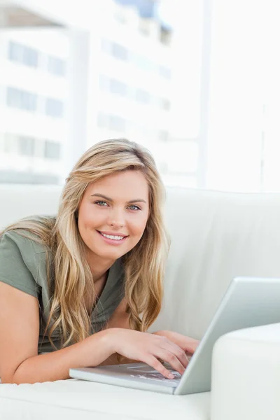 Närbild, kvinnan ler och ser fram emot med sin laptop i f — Stockfoto