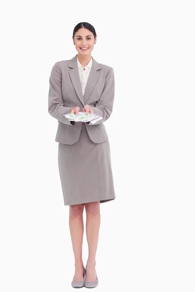 Усміхнена молода бізнес-леді з банкнотами в її руках — стокове фото