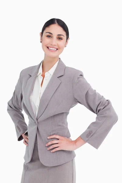 Smiling saleswoman with hands on her hip — Stock Photo, Image