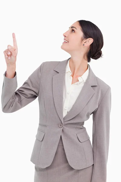 Smiling businesswoman looking and pointing up — Stock Photo, Image