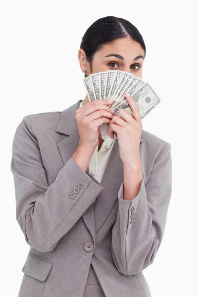 Jovem vendedora escondendo seu rosto atrás de notas bancárias — Fotografia de Stock
