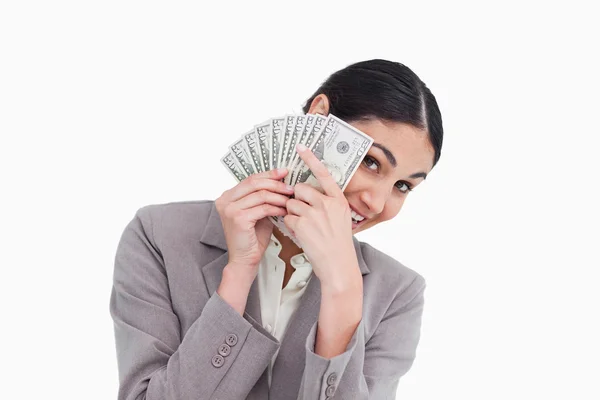 Jonge verkoopster die betrekking hebben op haar gezicht met bank notes — Stockfoto