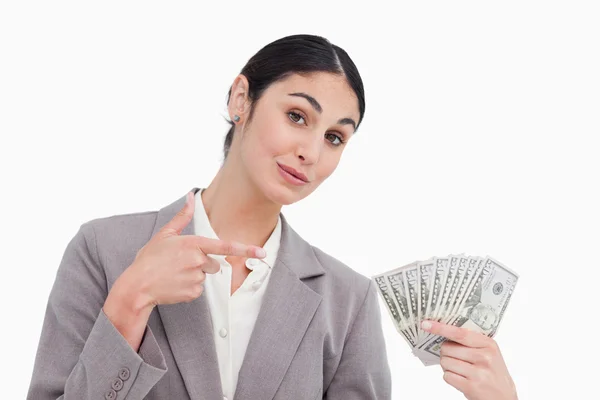 Saleswoman pointant vers les billets de banque dans sa main — Photo
