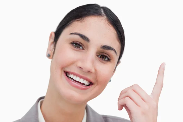 Крупным планом улыбающейся деловой женщины, указывающей — стоковое фото