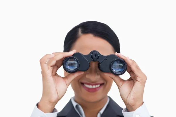Close up of smiling saleswoman using spy glasses — Stock Photo, Image