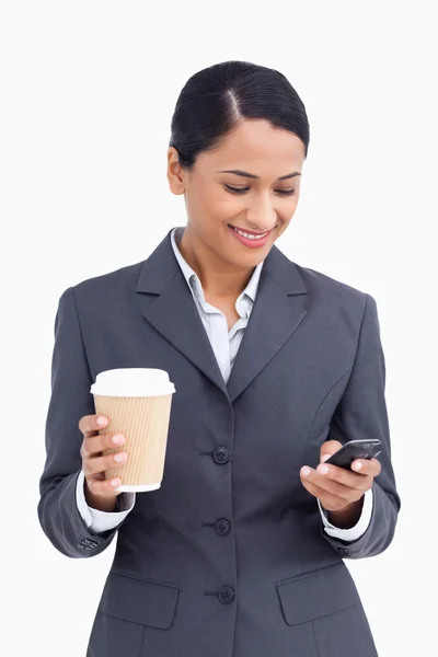 Nahaufnahme einer Verkäuferin mit Pappbecher, die SMS liest — Stockfoto