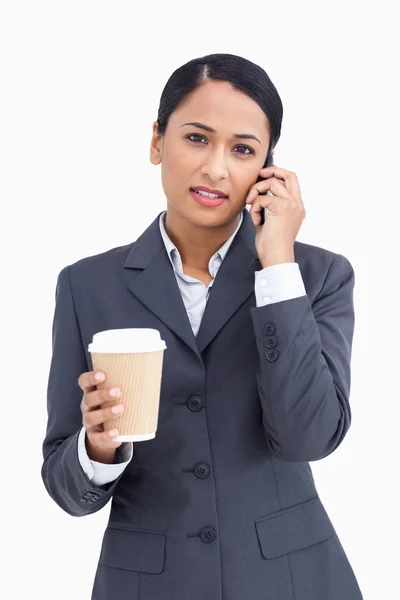 Närbild på seriösa försäljare med papper kopp och mobiltelefon — Stockfoto