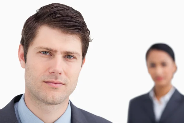Close up of young salesman with colleague behind him — Stock Photo, Image