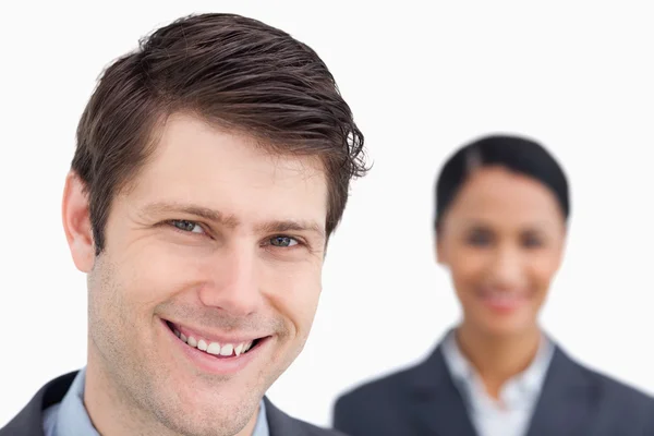 Close up of young salesman with colleague behind him against — Stock Photo, Image