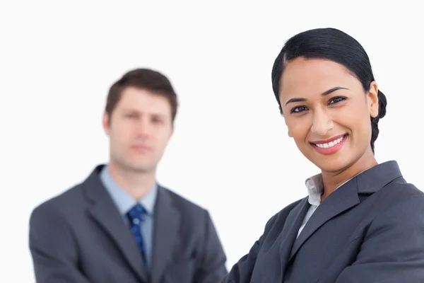 Close up of smiling saleswoman with co-worker behind her — Stock Photo, Image