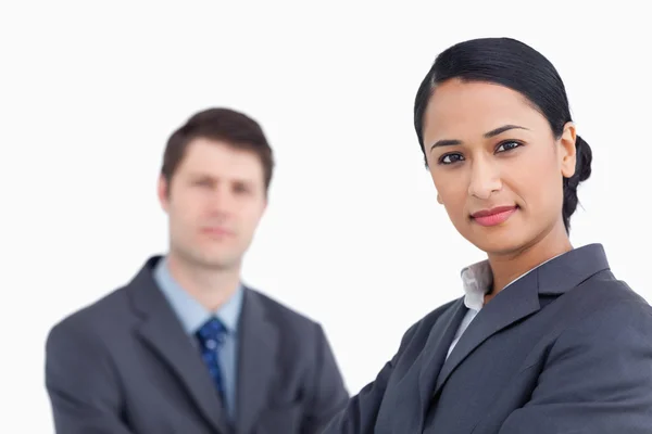 Close up of confident saleswoman with co-worker behind her — Stock Photo, Image