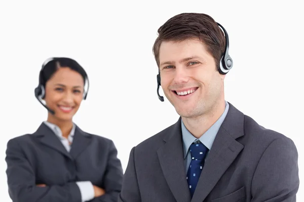 Detailní záběr usmívající se muž volání centrum agent s kolegy za — Stock fotografie
