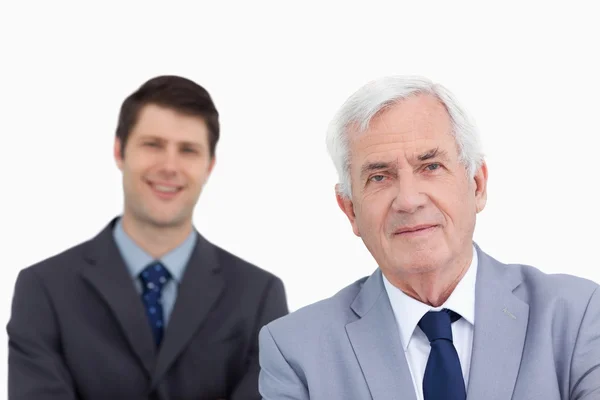 Крупный план зрелого бизнесмена с коллегой позади него — стоковое фото