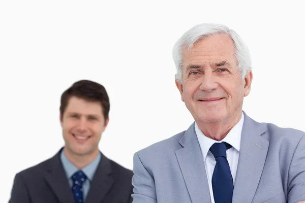 Close up van volwassen zakenman met werknemer achter hem — Stockfoto