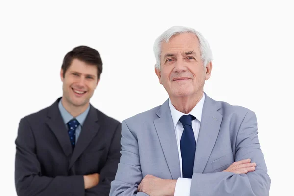 Close up of mature businessman with folded arms and colleague be — Stock Photo, Image
