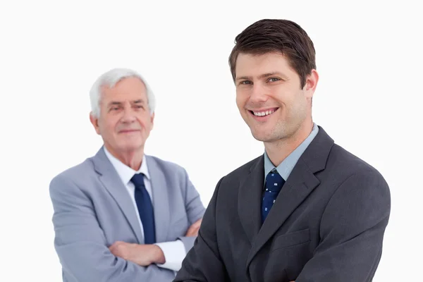 Close up of smiling businessman with his mentor behind him — Stock Photo, Image