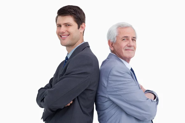 Close up of businessman and his mentor standing back to back — Stock Photo, Image