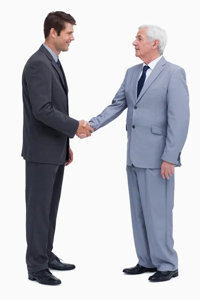 Молодые и зрелые бизнесмены пожимают руки — стоковое фото