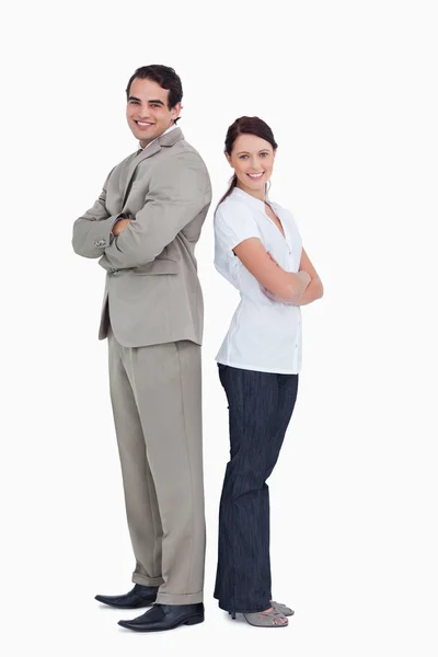 Smiling salesteam with arms folded standing back to back — Stock Photo, Image