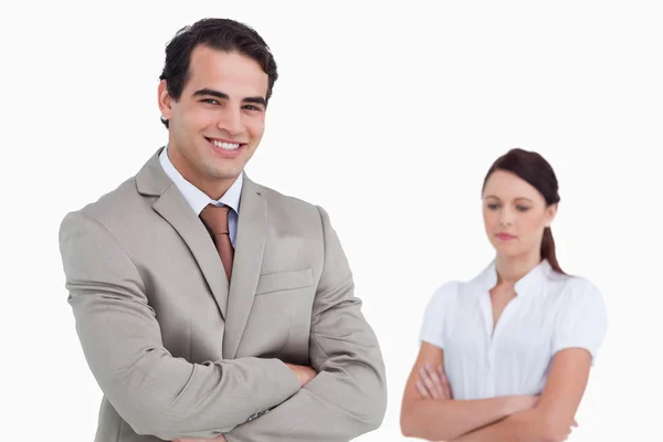 Smiling salesman with colleague behind him — Stock Photo, Image