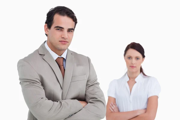 Salesman with arms crossed and colleague behind him — Stock Photo, Image