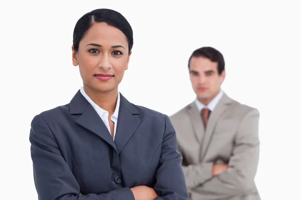 Saleswoman with arms crossed and colleague behind her — Stock Photo, Image