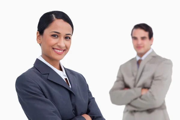 Smiling saleswoman with colleague behind her — Stock Photo, Image