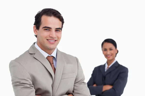 Smiling salesman with co-worker behind him — Stock Photo, Image