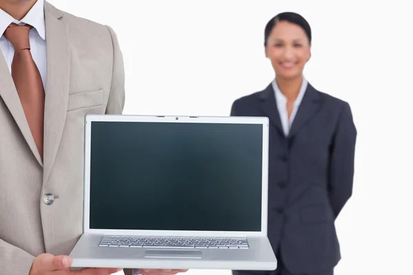 Laptop siendo presentado por el vendedor con colega detrás de él — Foto de Stock