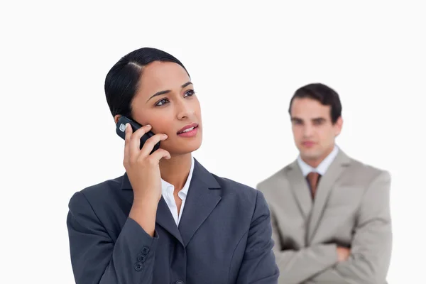 Saleswoman with colleague behind her listening closely to caller — Stock Photo, Image