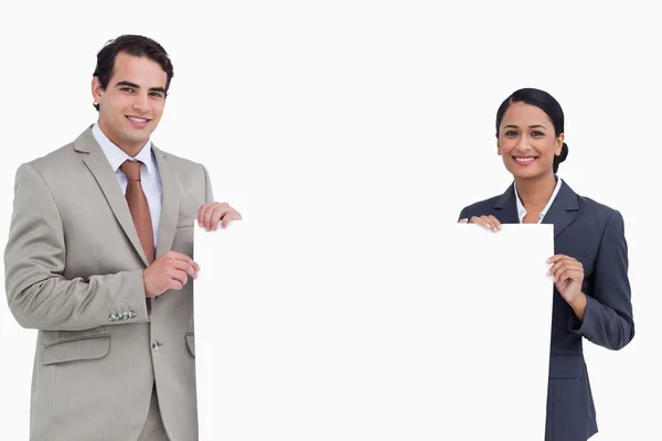 Smiling salesteam holding blank sign — Stock Photo, Image