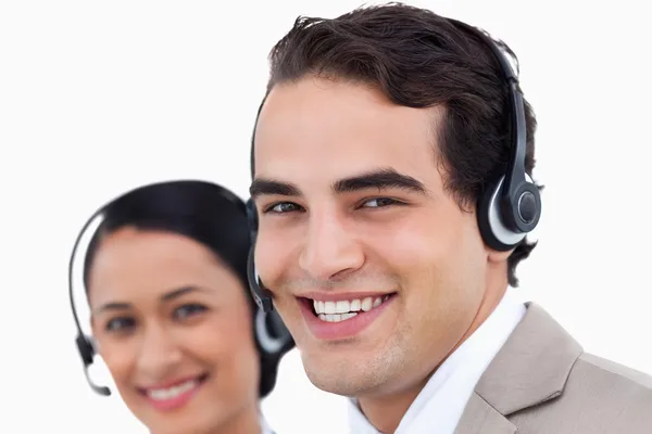 Close up vista lateral de sorrindo agentes de call center no trabalho — Fotografia de Stock