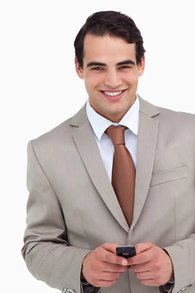 Primer plano de vendedor sonriente sosteniendo su teléfono celular — Foto de Stock