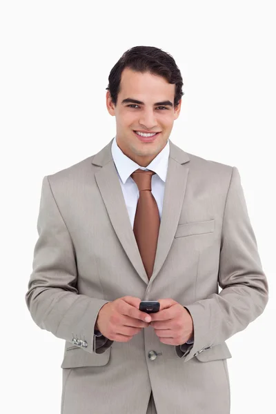 Uśmiechnięty sprzedawca trzyma swój telefon komórkowy — Zdjęcie stockowe