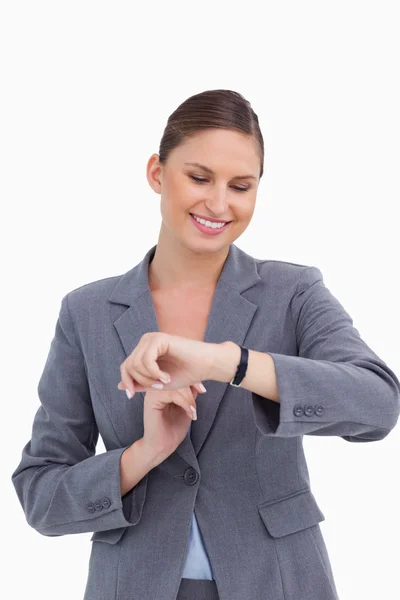 Uśmiechnięta kobieta, patrząc na zegarek — Zdjęcie stockowe