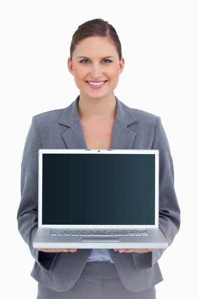 Улыбающаяся торговая женщина представляет экран своего ноутбука — стоковое фото