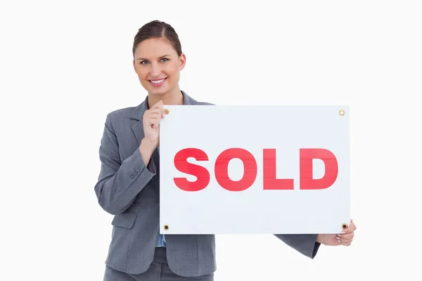 Happy real estate agent with sold sign — Stock Photo, Image