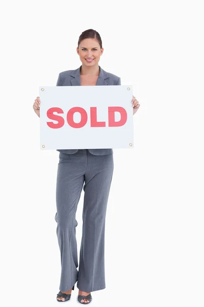Feliz agente imobiliário segurando sinal vendido — Fotografia de Stock