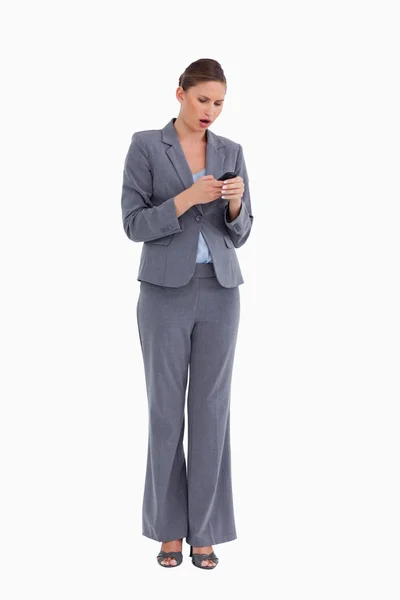 Shocked tradeswoman reading text message — Stock Photo, Image