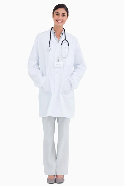 Lächelnde Ärztin mit Händen in den Taschen — Stockfoto
